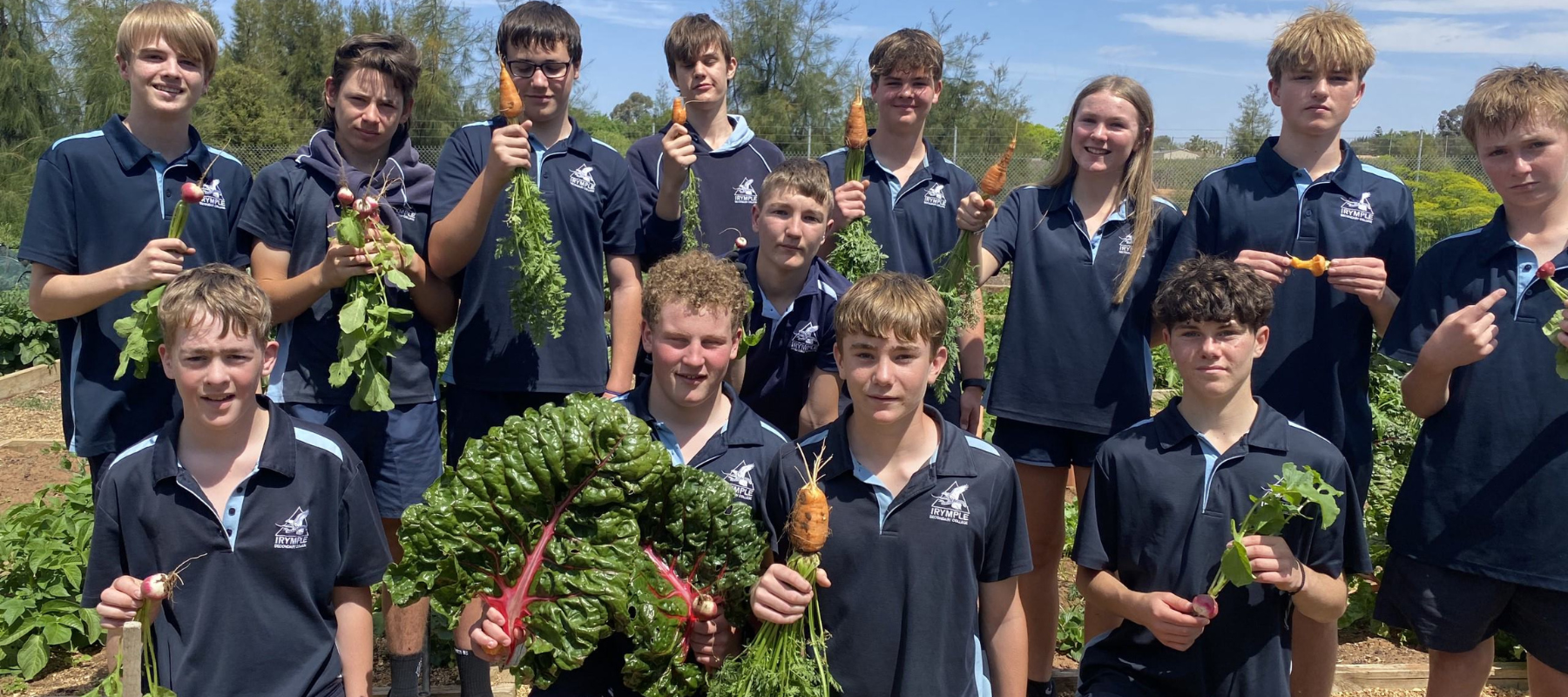 Students holding up produce grown from their school garden